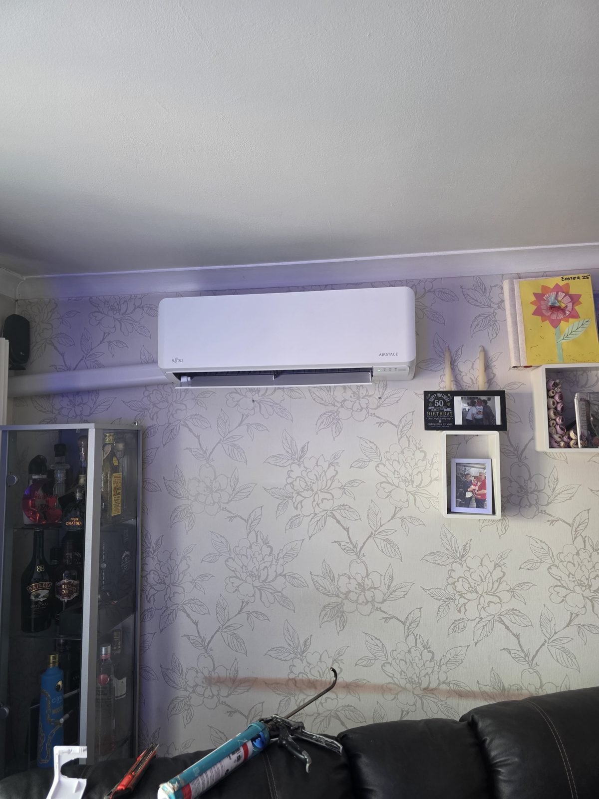Indoor wall-mounted Fujitsu air conditioning unit installed in a living room.