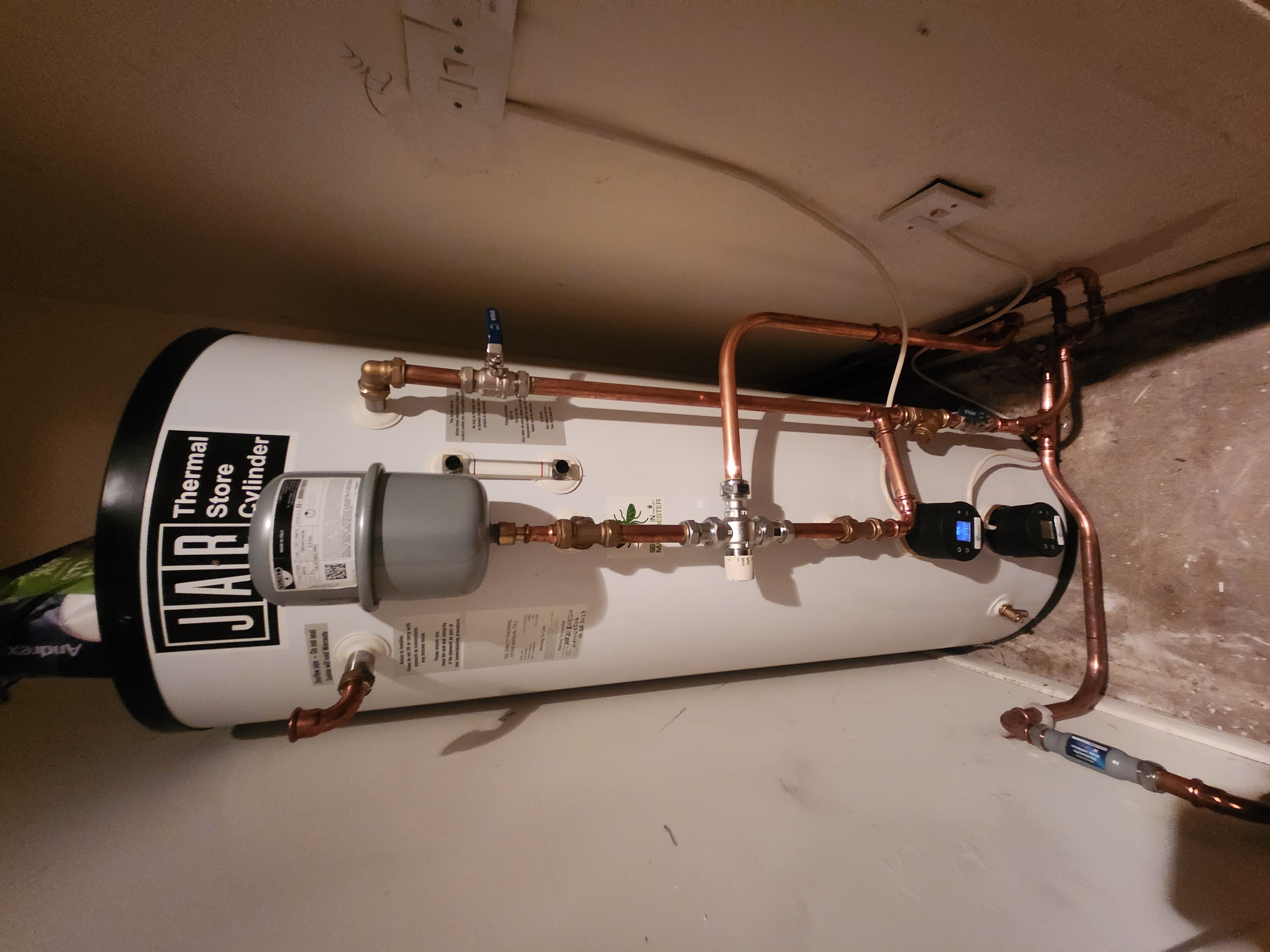 JAB Thermal Store Cylinder installed in a cupboard with exposed copper pipework, expansion vessel and digital controls.