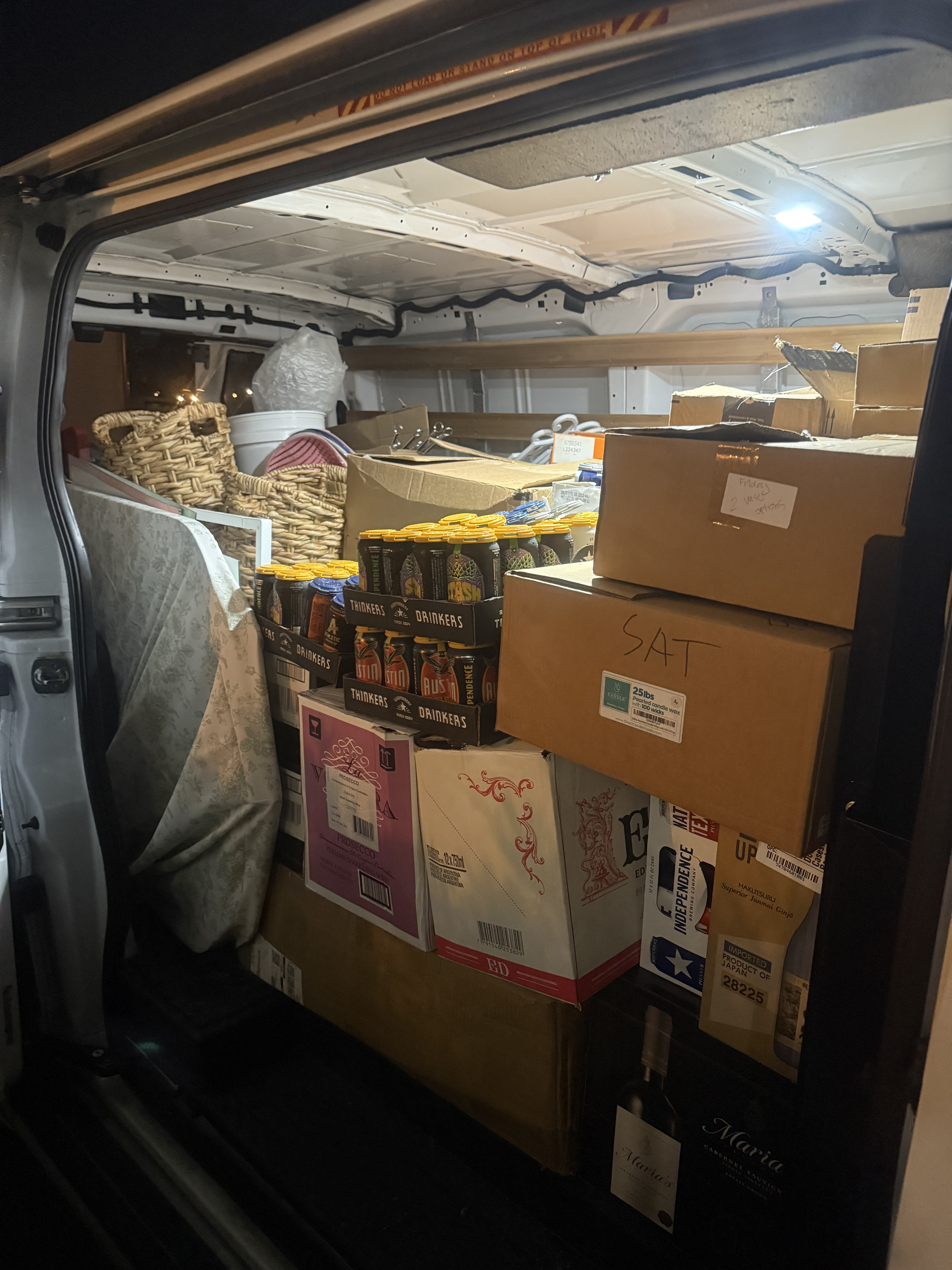 Van fully stocked with beverages, wine, boxes, and event supplies ready for delivery