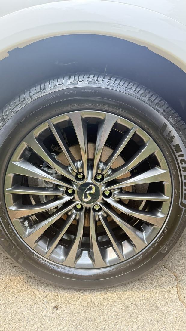 Close up of a polished multi spoke wheel and dressed tire after an Armenta's detail