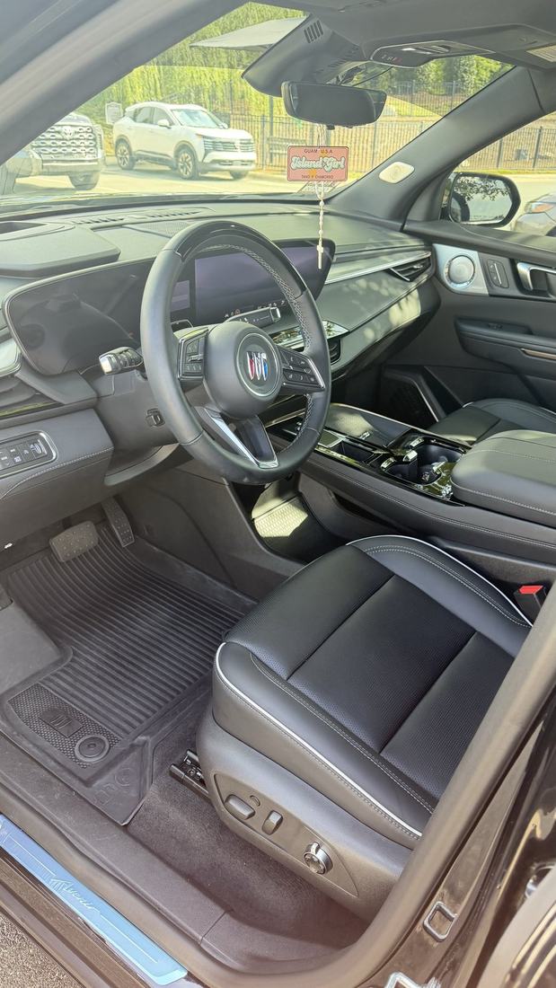 SUV interior after a detail showing cleaned light leather seats, dashboard and touchscreen