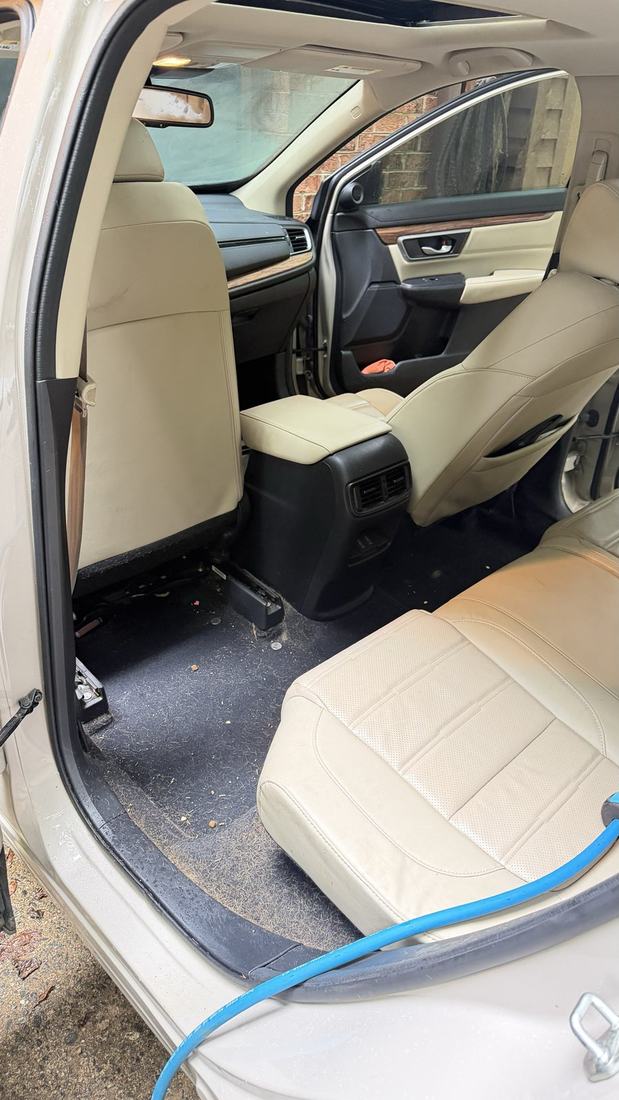 White SUV with the door open showing cream leather seats cleaned and conditioned
