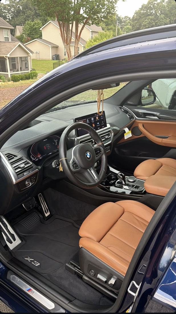 BMW X3 interior after a detail showing cleaned cognac leather seats and dashboard