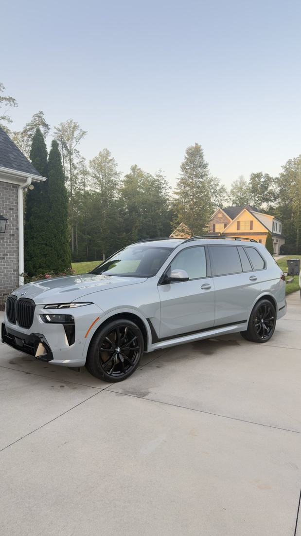 Grey BMW X7 SUV after a full exterior detail in a residential driveway