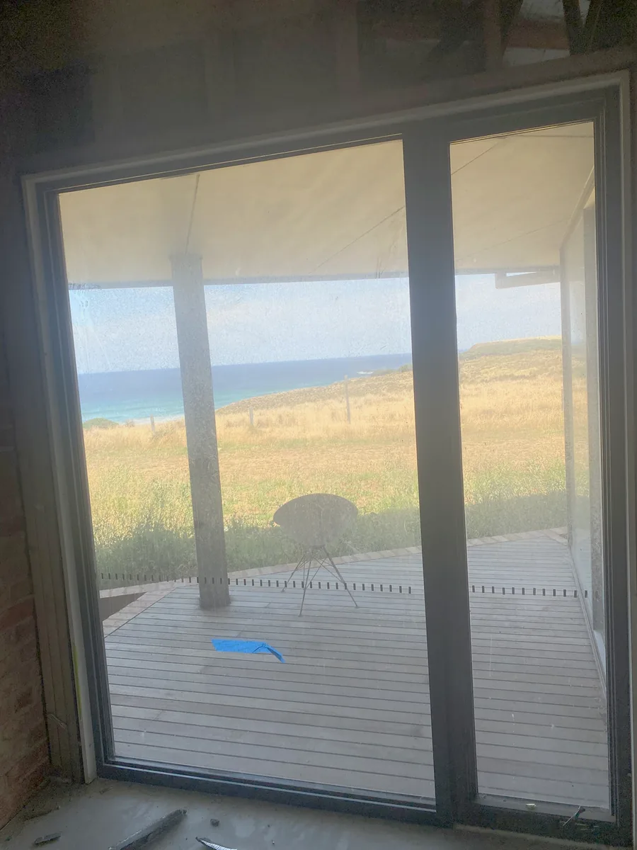 Full height sliding door heavily coated in construction dust before cleaning