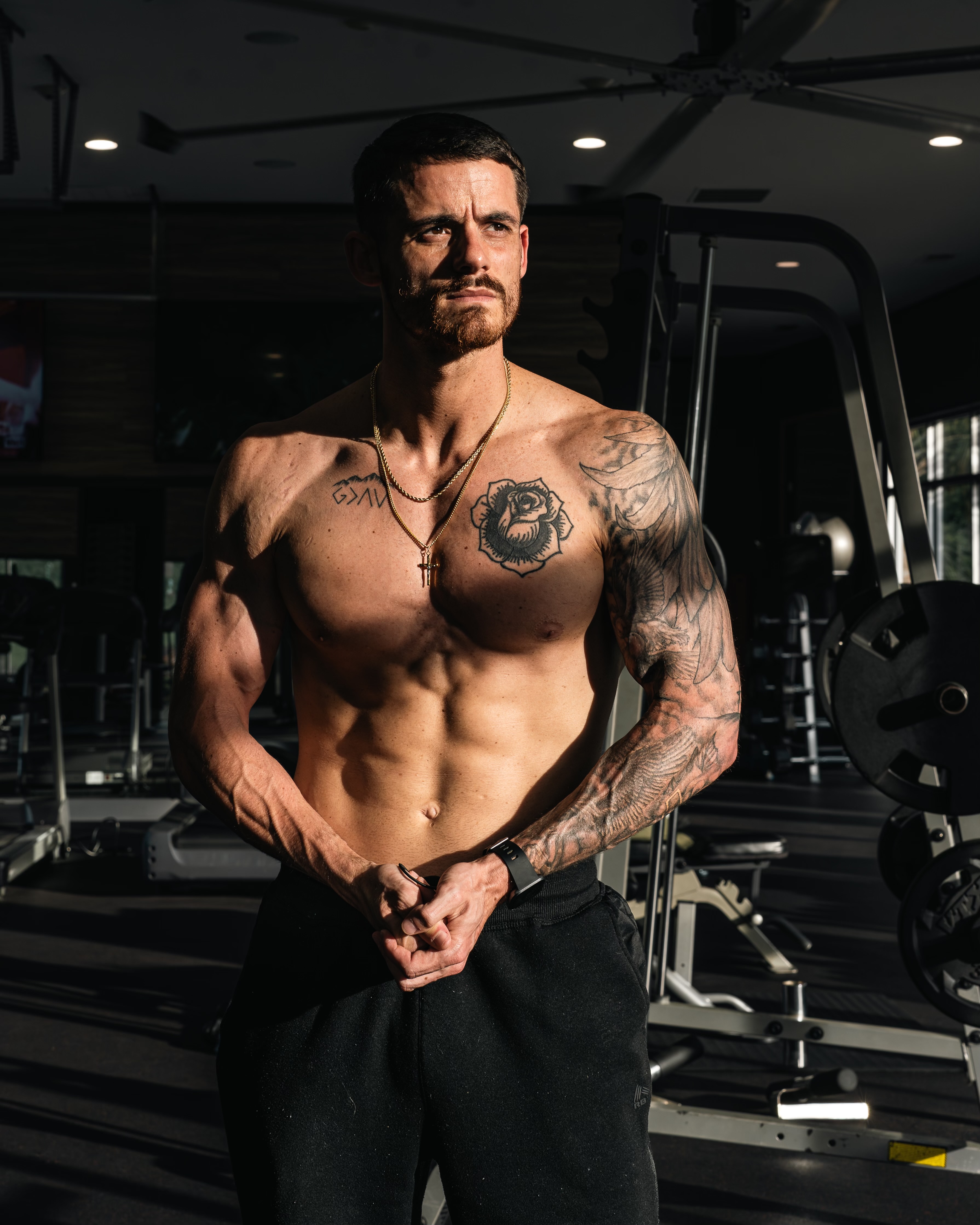 Muscular coach standing confidently in a modern gym