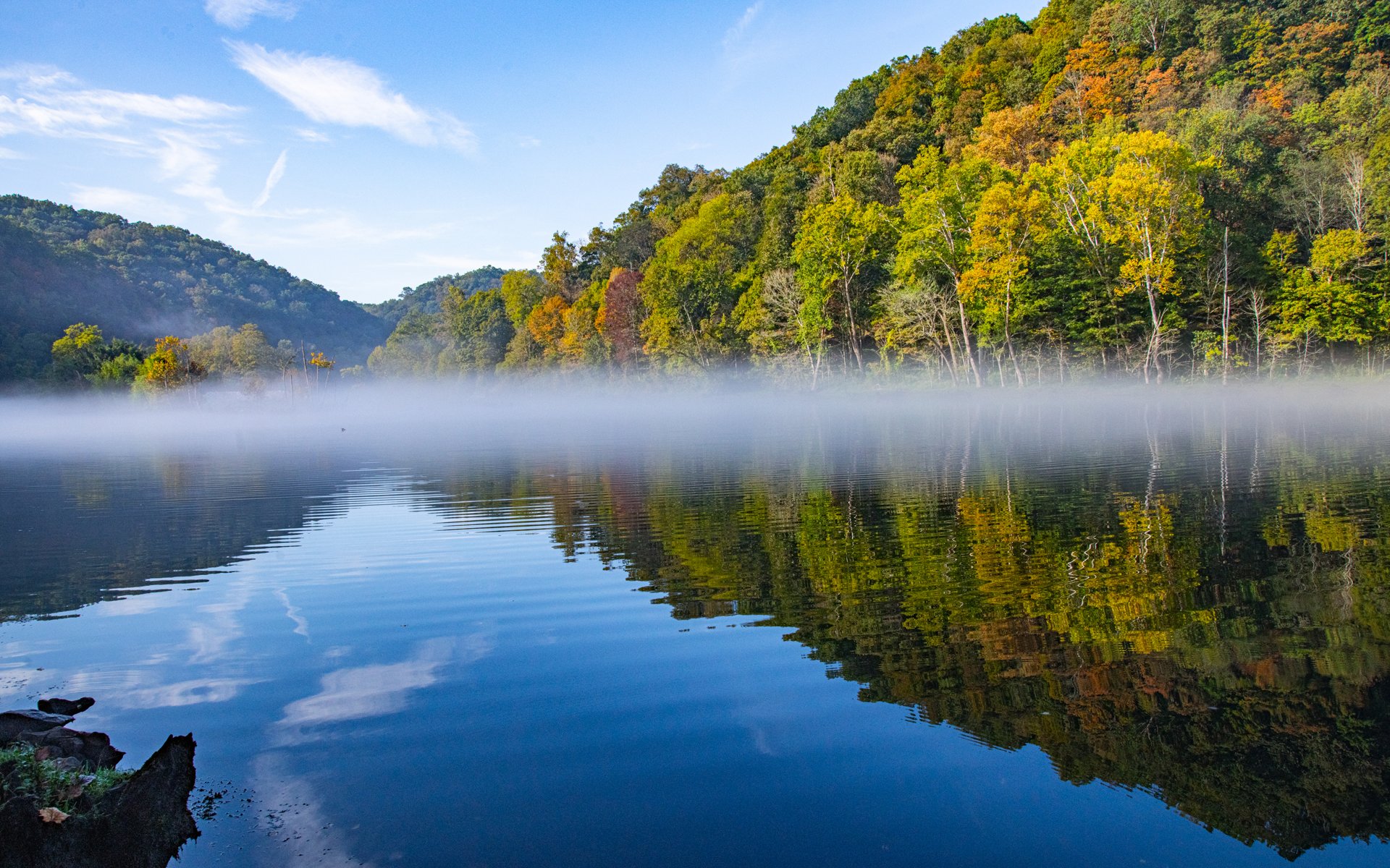 Scenic East Tennessee lake with misty morning reflections and vibrant foliage