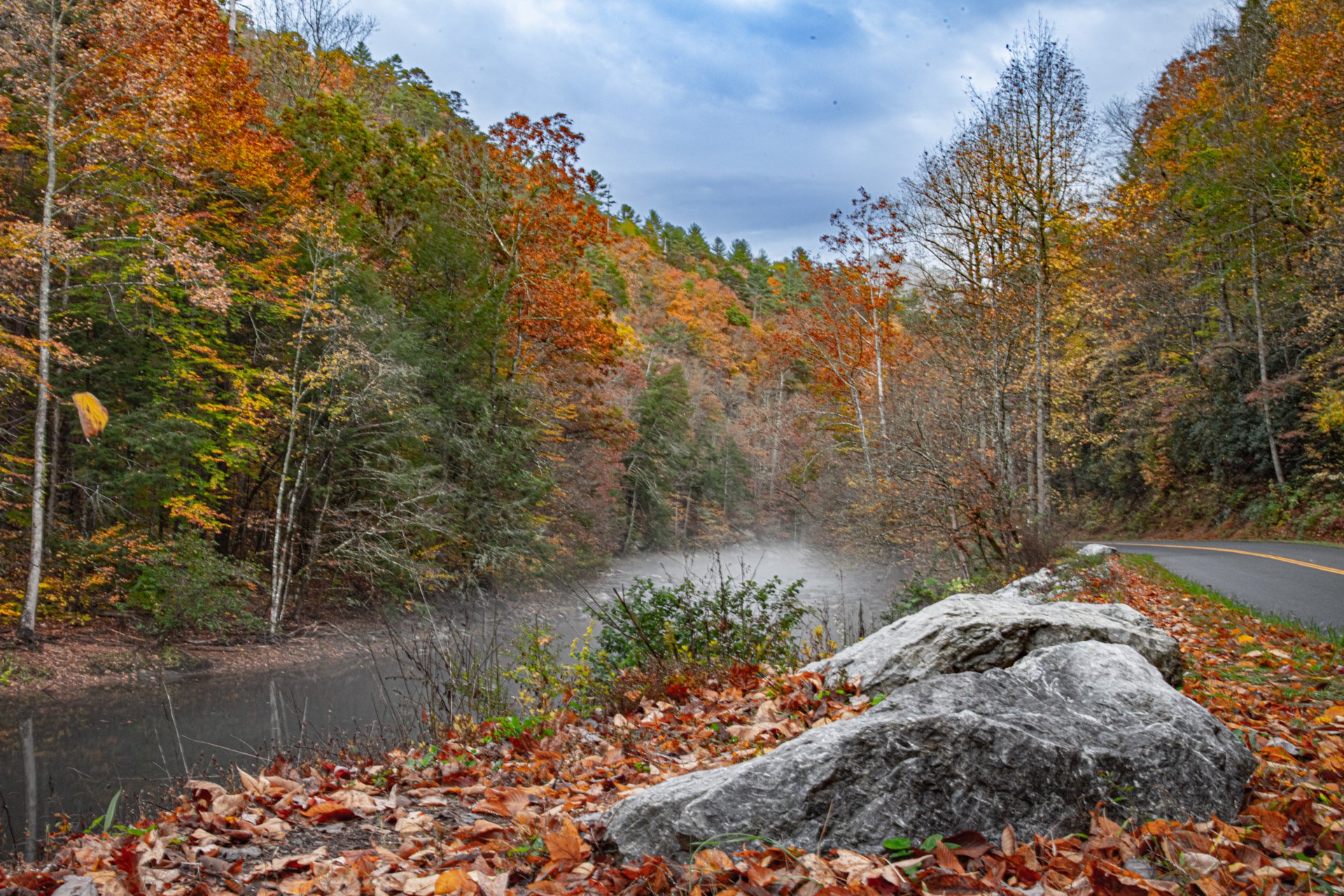 Autumn road winding past a calm lake in the Great Smoky Mountains region of East Tennessee