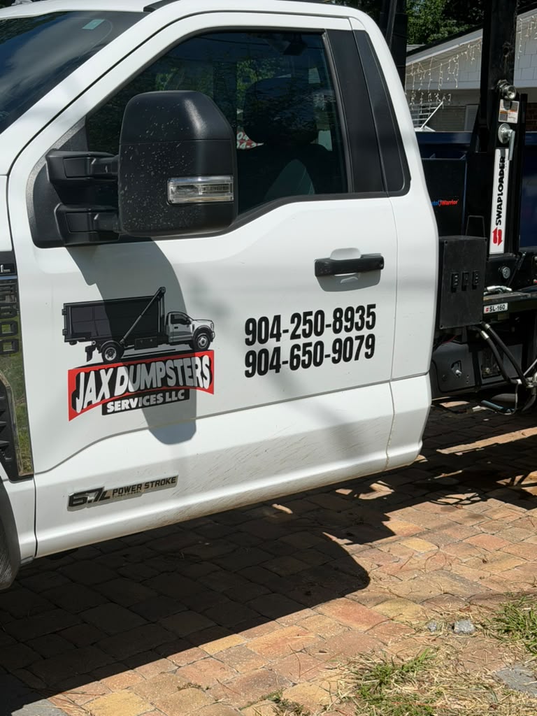 JAX Dumpsters branded truck showing company logo and contact numbers