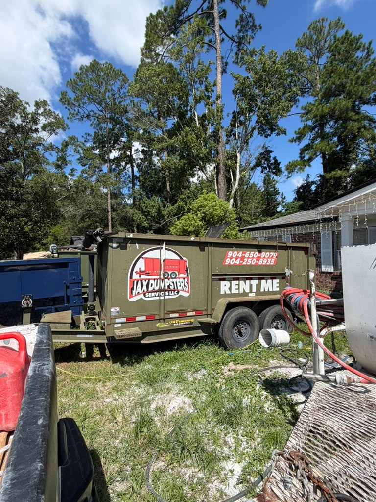Olive green JAX Dumpsters rental container with RENT ME branding at Jacksonville property