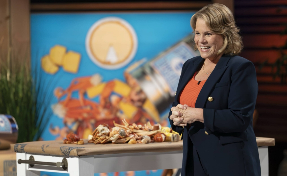 Danielle on Shark Tank stage with Topsail Steamer seafood display