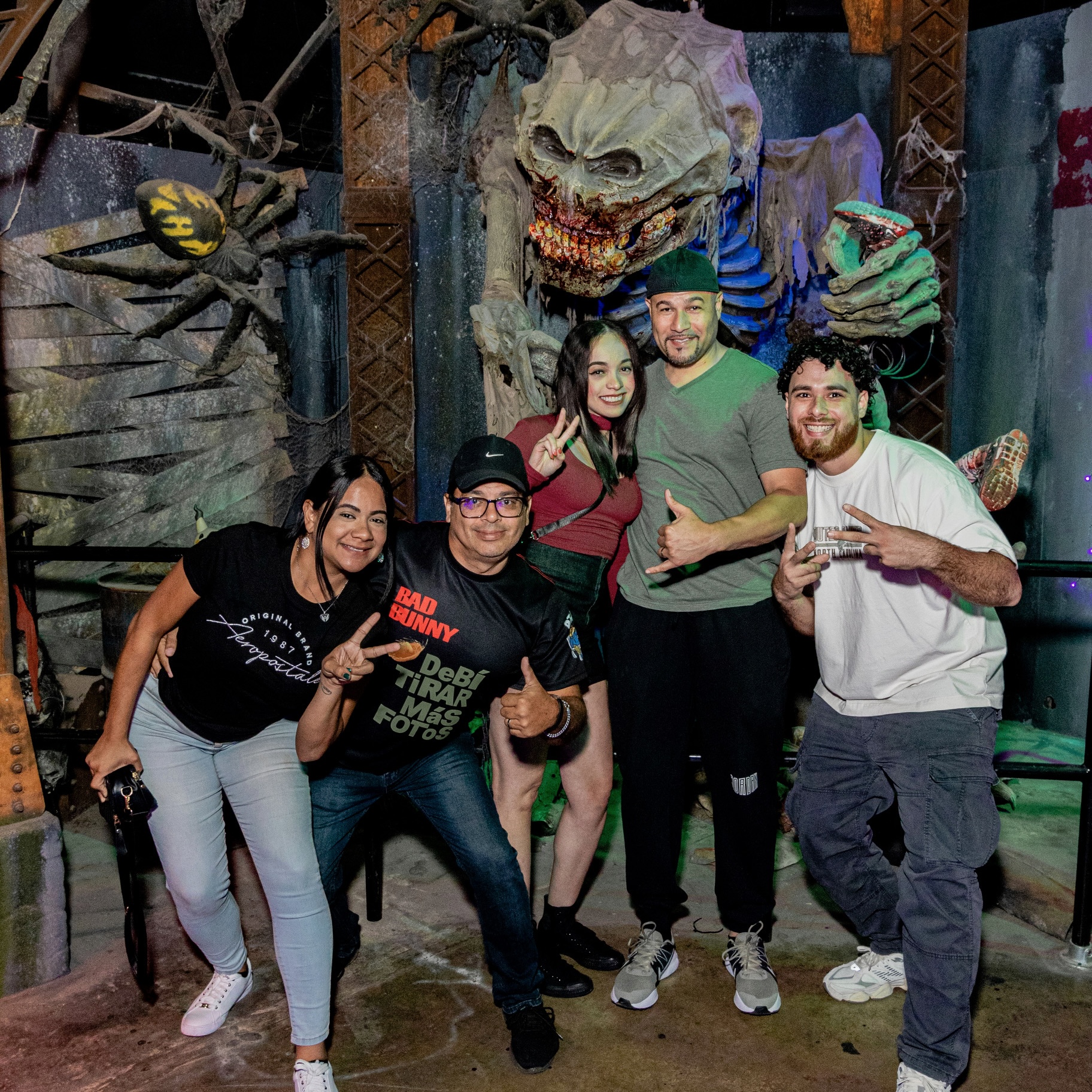 Guests posing at Halloween souvenir photo op with monster at Massacre Haunted House