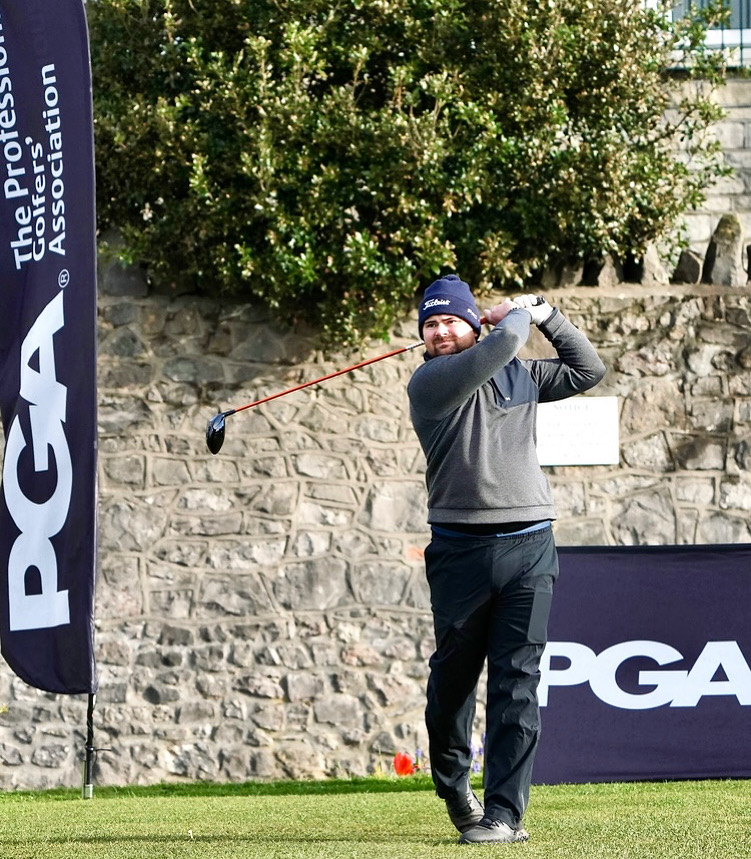 Oli Balchin coaching a golfer on the driving range
