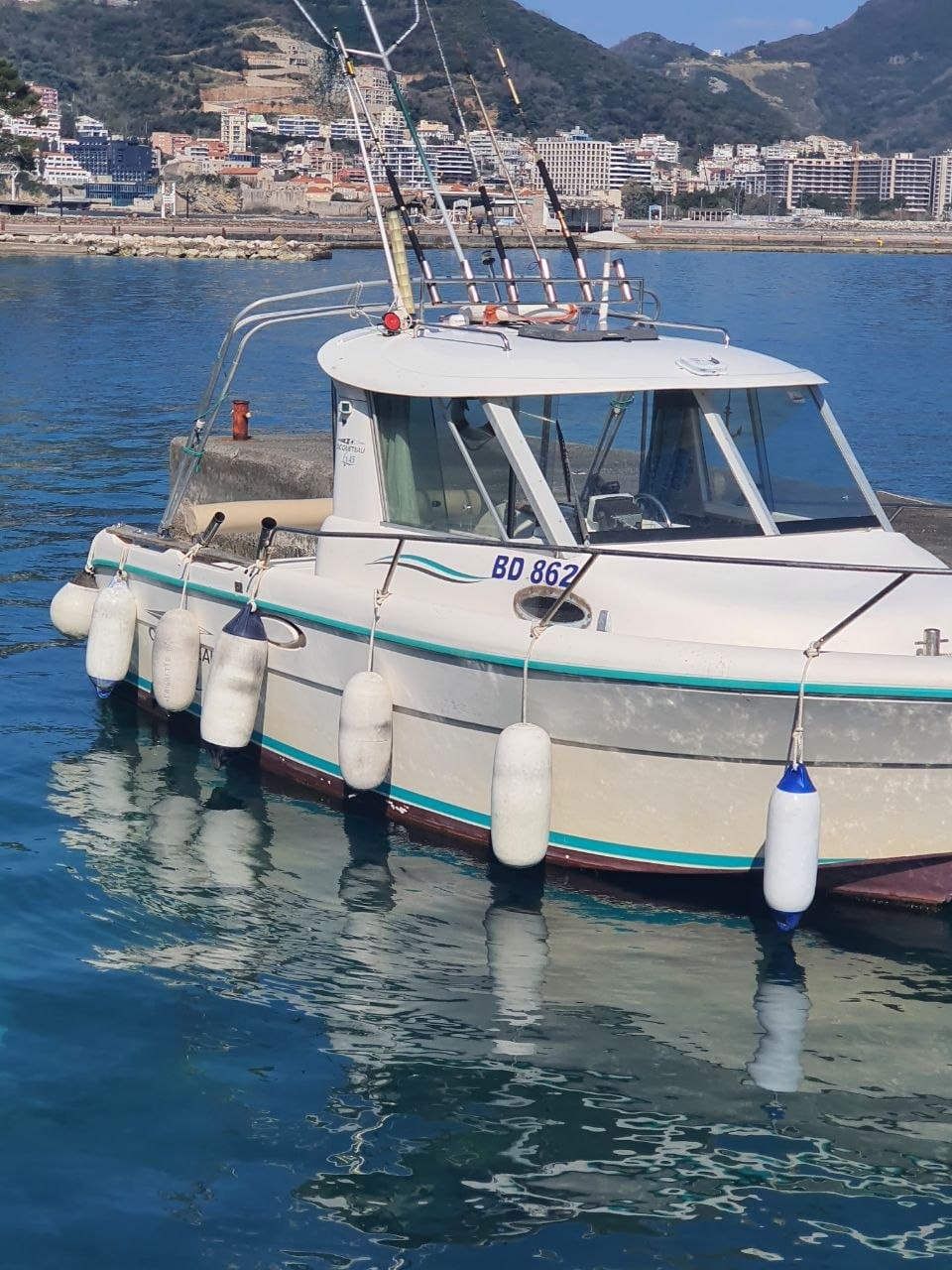 Private boat moored in Budva harbour with turquoise Adriatic water