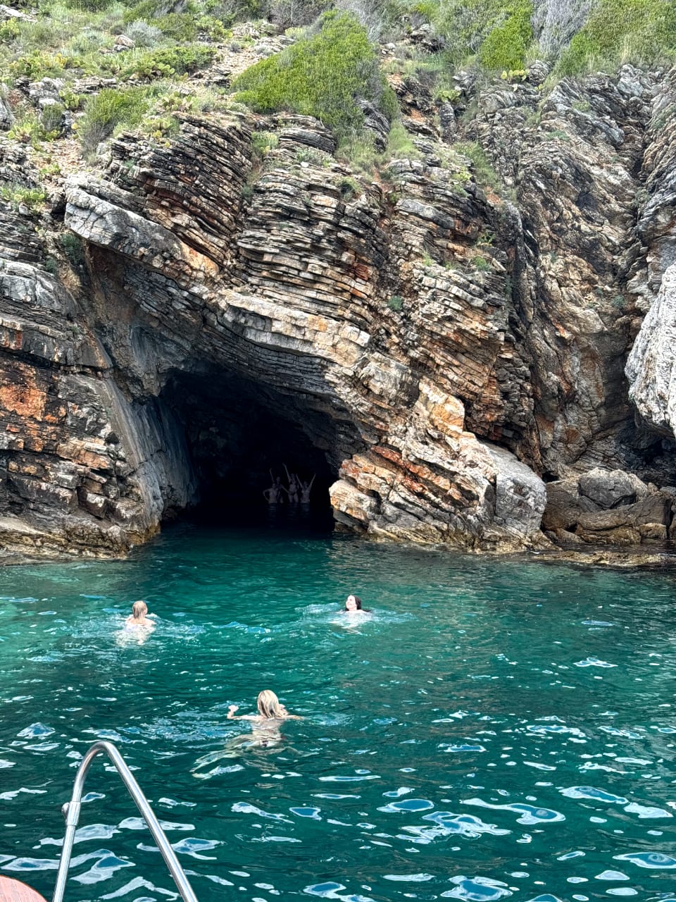Guests swimming into hidden sea cave entrance