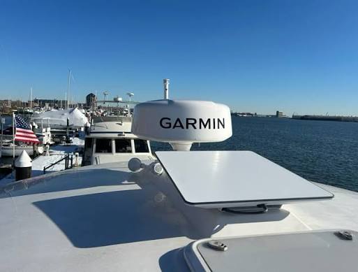 Starlink flat panel satellite antenna installed on a yacht hardtop alongside marine radar at a marina