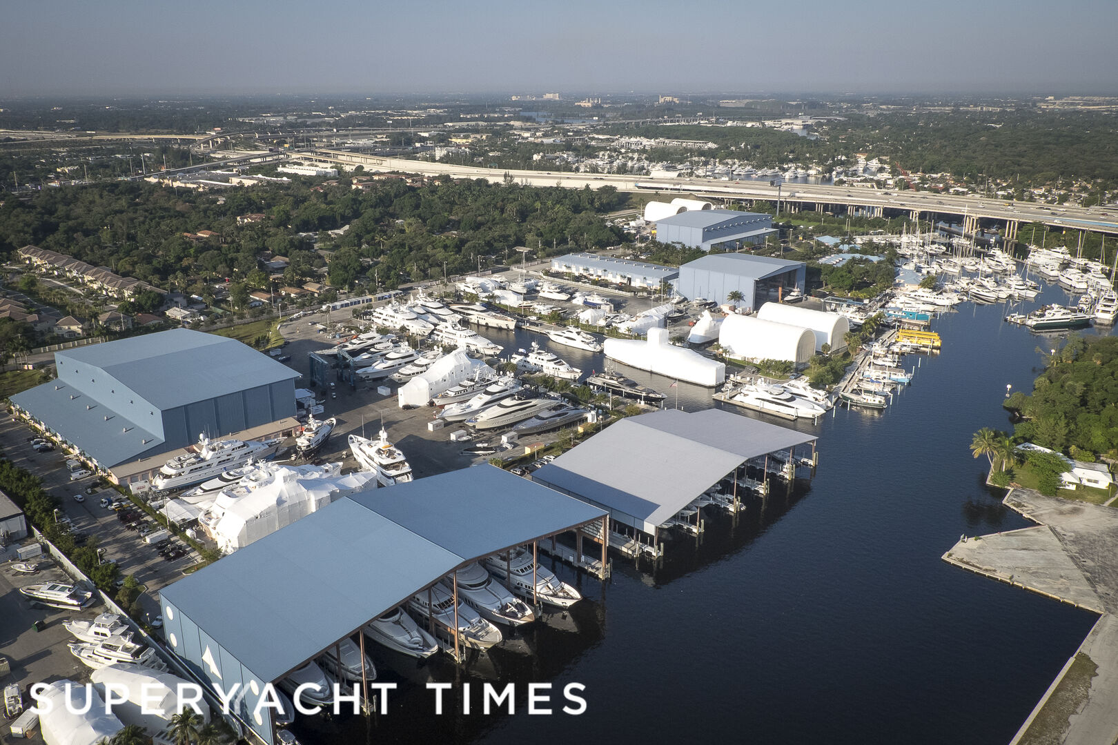 Aerial view of Lauderdale Marine Center shipyard in Fort Lauderdale with yachts in covered refit slips and on the hard