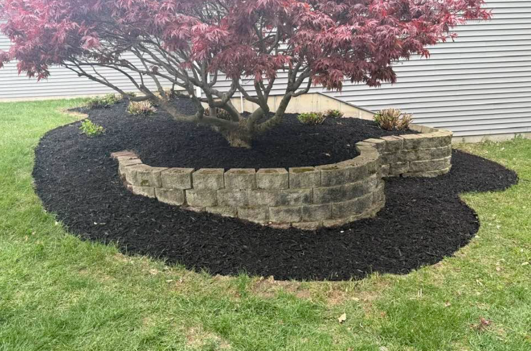 Retaining wall with landscape beds and natural slope in a West Michigan yard