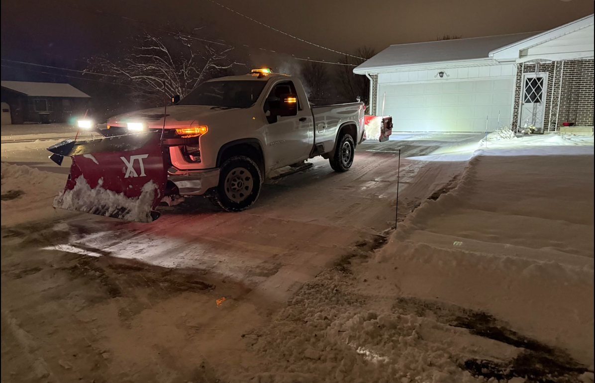 Snow plow truck clearing snow at night
