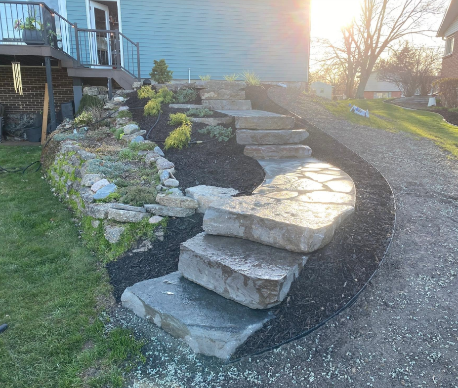 Stone paver walkway winding through a West Michigan backyard with landscape beds