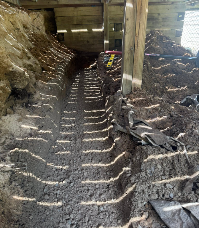 Drainage installation work around a West Michigan landscape bed