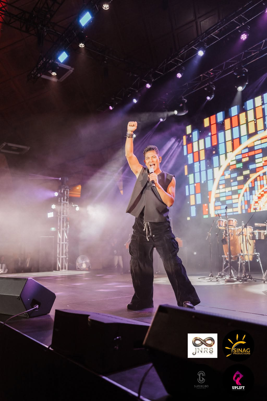 Gary Valenciano with fist raised in pure celebration and joy under the stage lights, bringing the crowd to their feet.