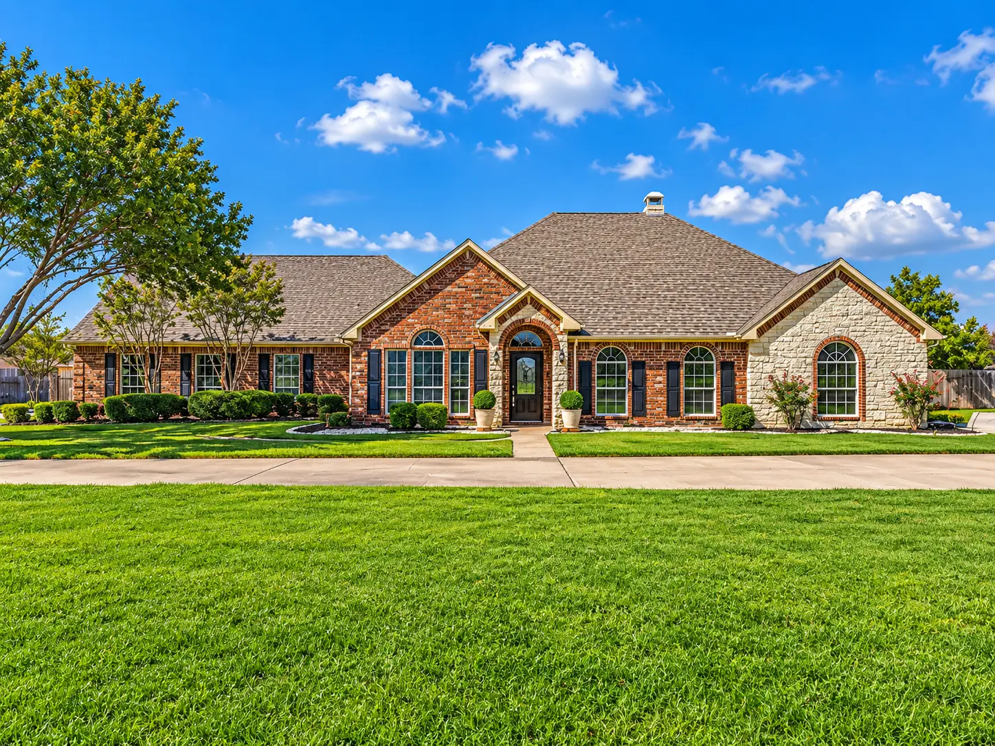 Distinctive Texas brick and stone estate home with manicured green lawn