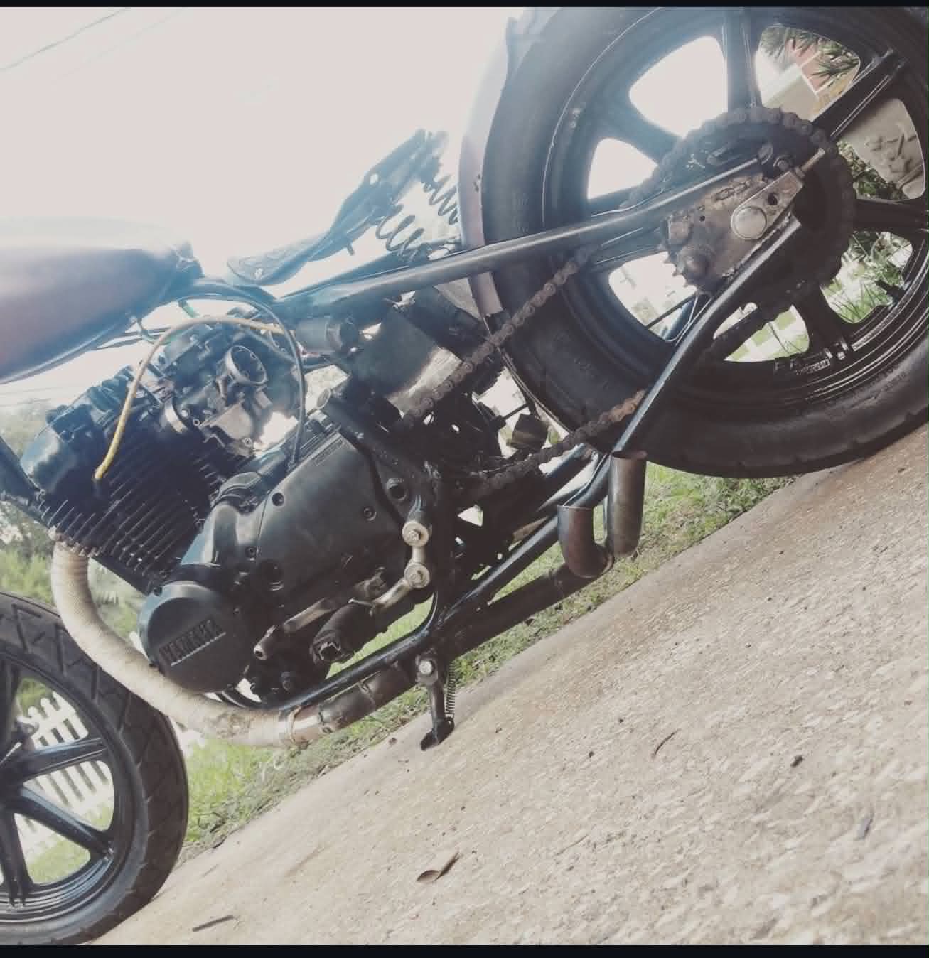 Custom motorcycle engine rebuild with polished exhaust system at Marlito workshop