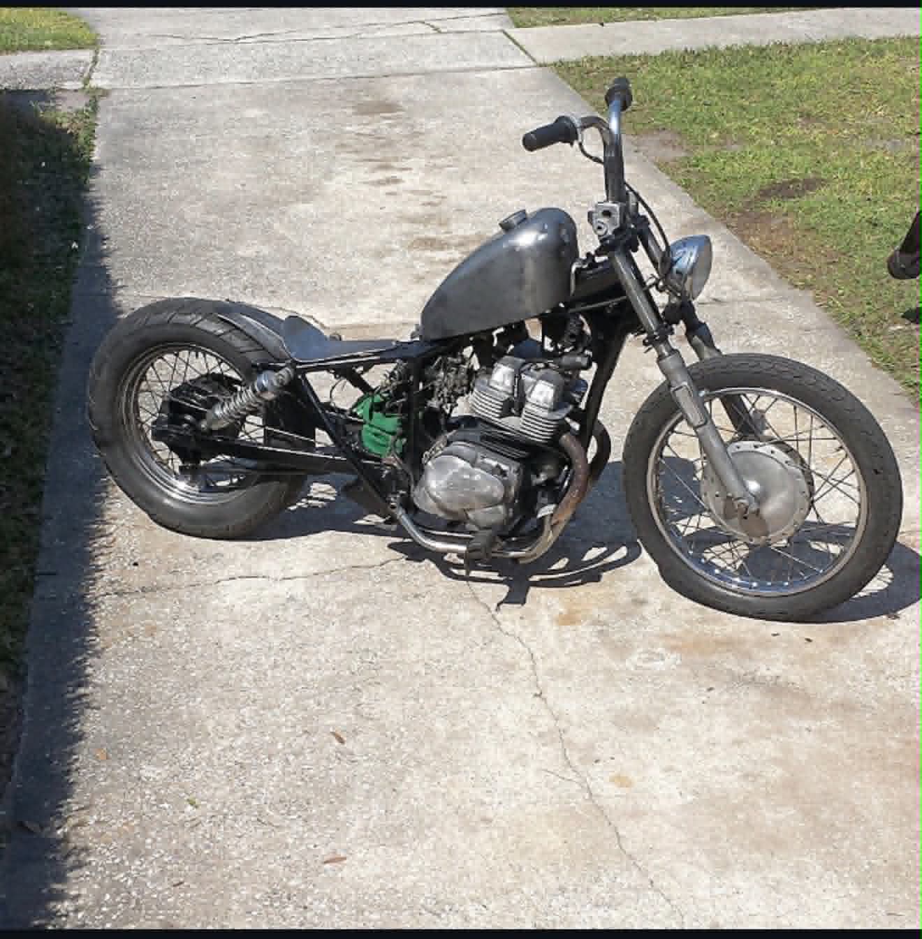 Silver custom bobber with wire-spoke wheels and exposed engine by Marlito Motorcycles
