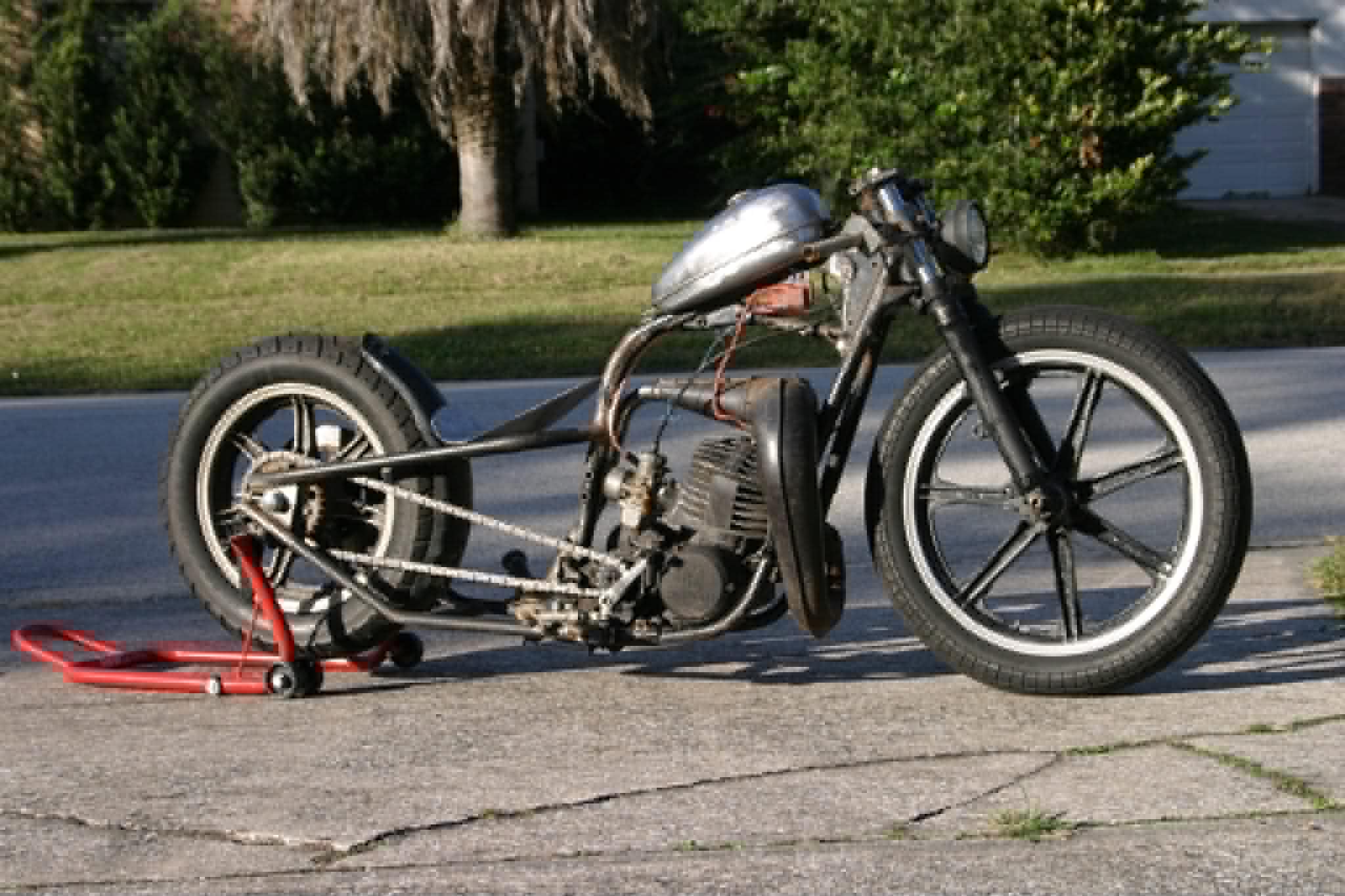 Motorcycle frame on red paddock stand during restoration at Marlito workshop