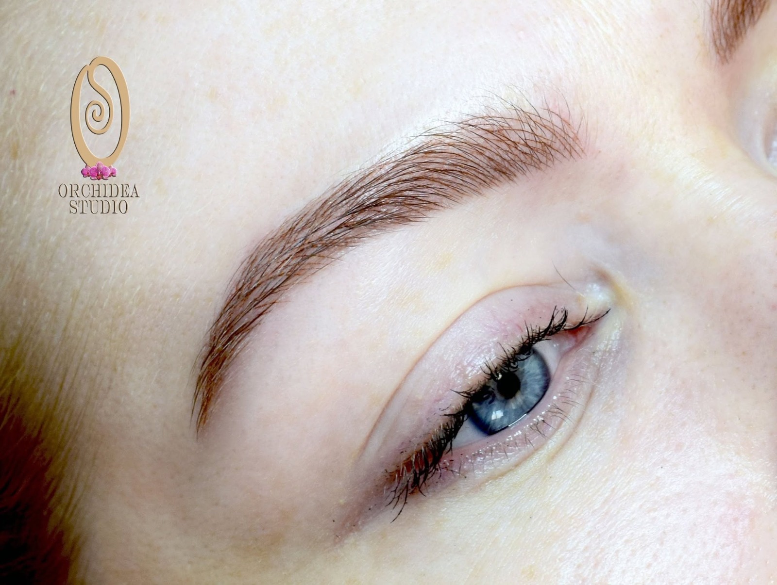 Szálas szemöldök tetoválás — kék szem, finom microblading vonalak, természetes hatás
