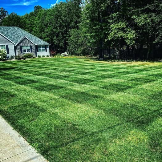 Freshly mowed lawn with professional striping pattern at an Akron home
