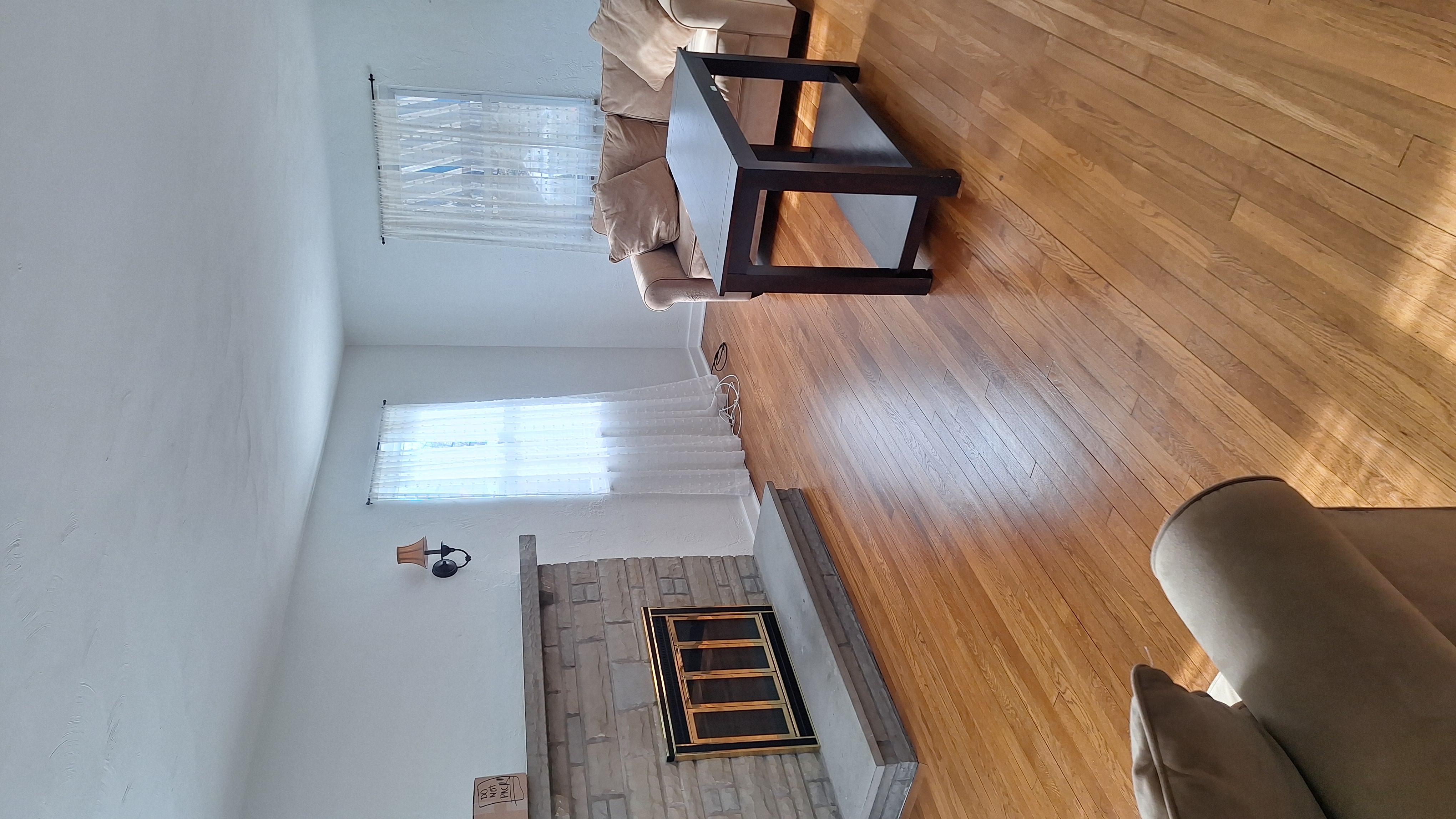 Clean, tidy living room with sofa, coffee table, and stone fireplace after house cleaning