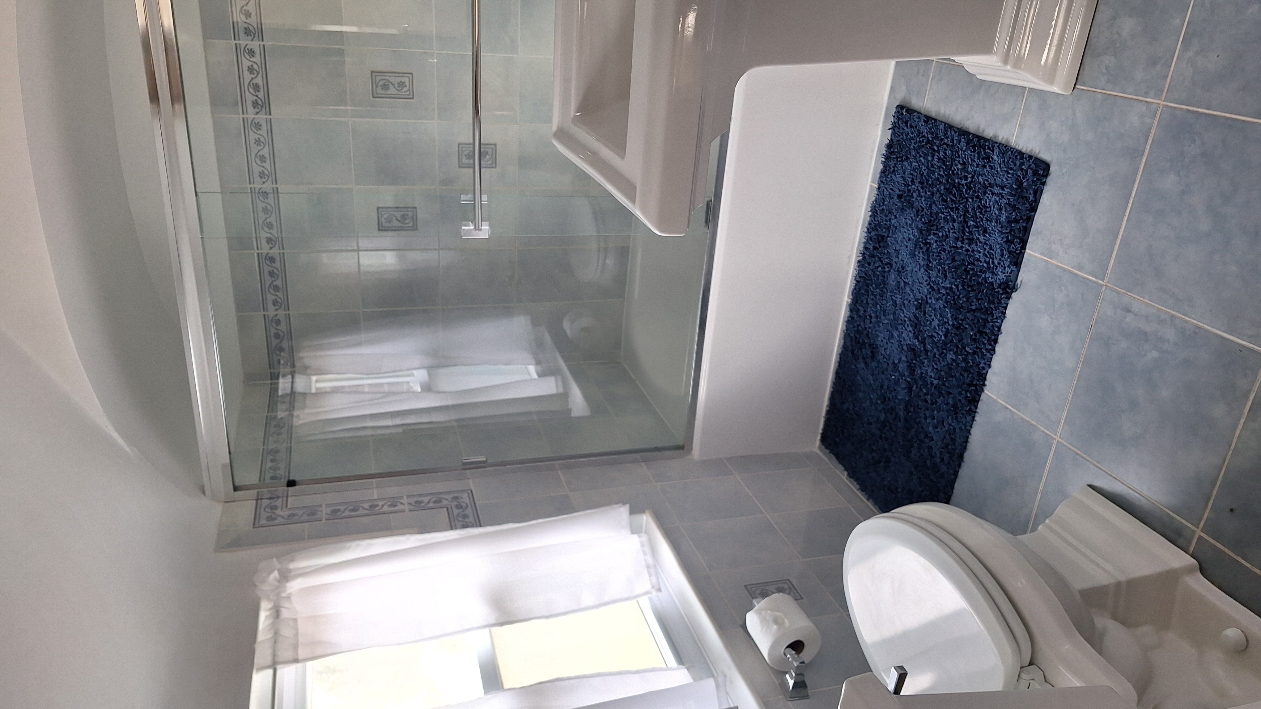 Scrubbed and sanitized bathroom with glass shower door, pedestal sink, and clean tile floor
