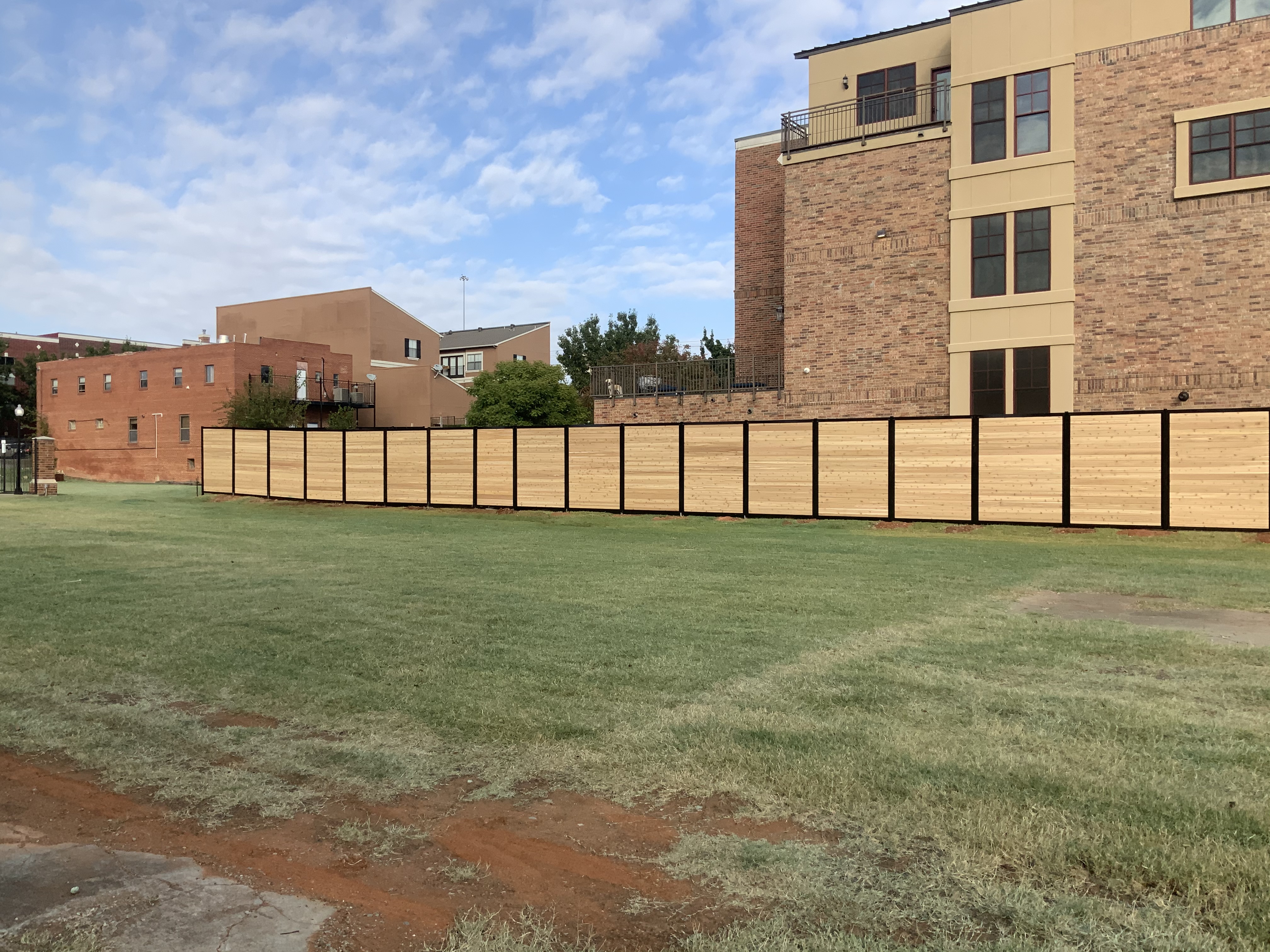 Modern horizontal Western Red Cedar fence panels framed by heavy black steel posts.