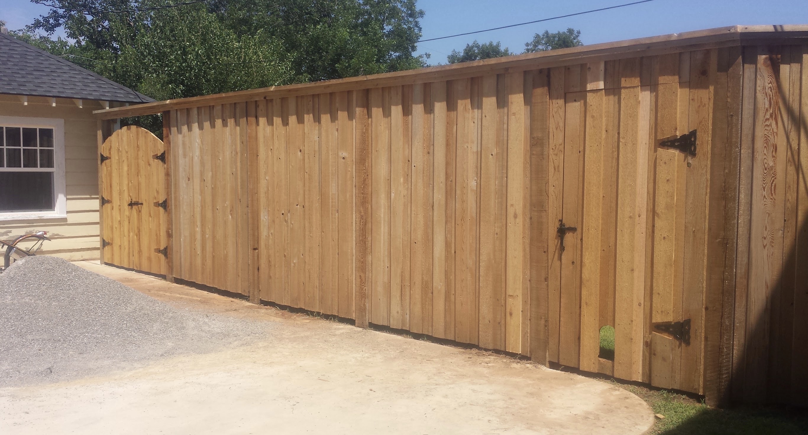 Western Red Cedar board on board privacy fence with top cap, double trim, arched gate, and walk gate with pet window.