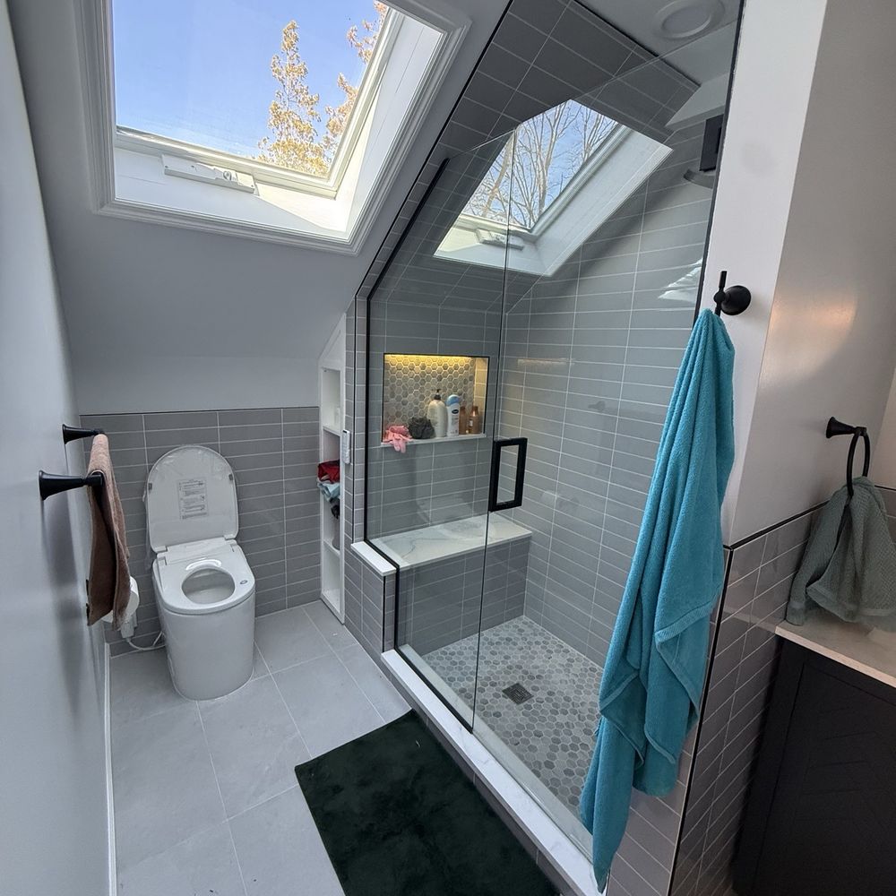 Custom bathroom remodel with skylight, walk-in glass shower, and gray tile work