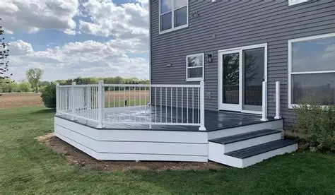 Custom ground-level platform deck with white railings and wrap-around steps