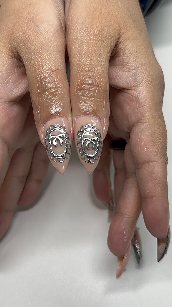 Elegant silver bow nail art on almond shaped nails