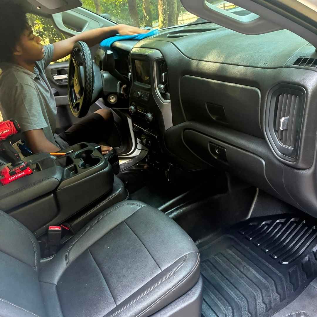 Morgan cleaning a truck interior on site