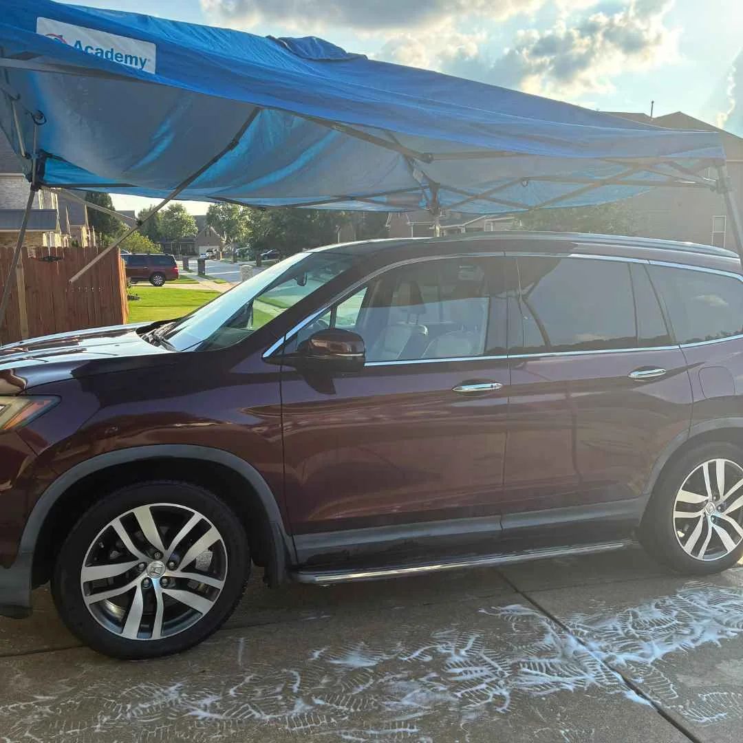 SUV being hand washed under Morgan's mobile canopy at a customer's home