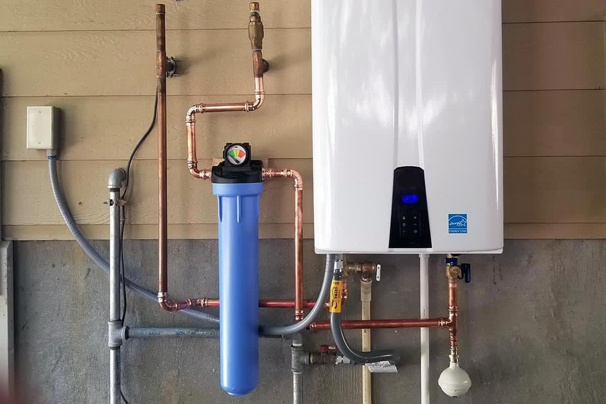 Newly installed tankless water heater mounted on a utility room wall