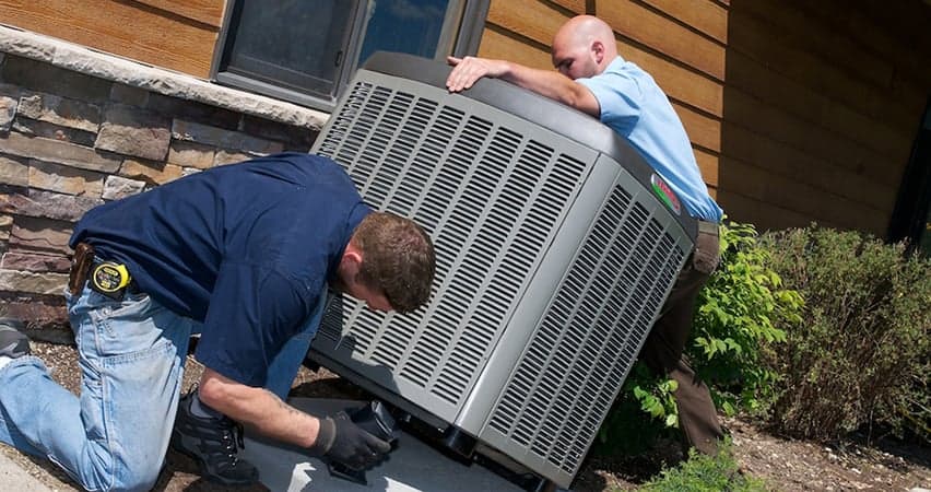 Service Champs HVAC team replacing an AC unit for a happy Saginaw customer