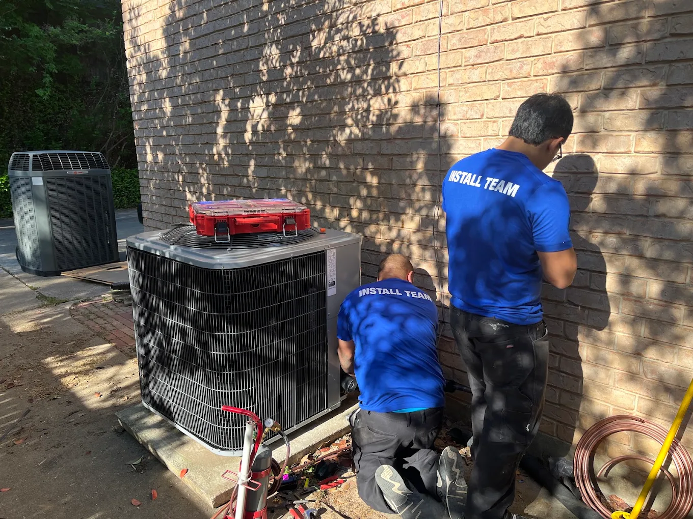Two Service Champs install technicians completing a new AC system installation