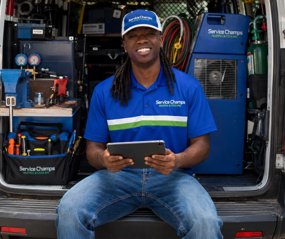 Service Champs technician in fully stocked service van with tablet