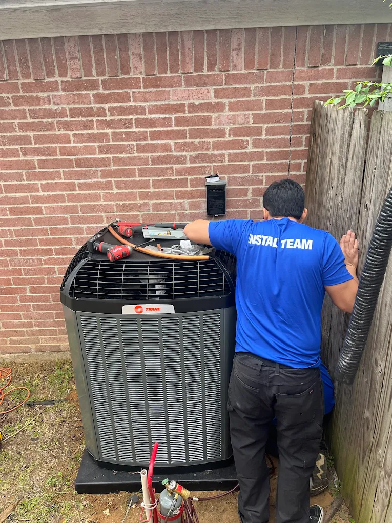 Install Team technician wiring a new Trane AC condenser unit