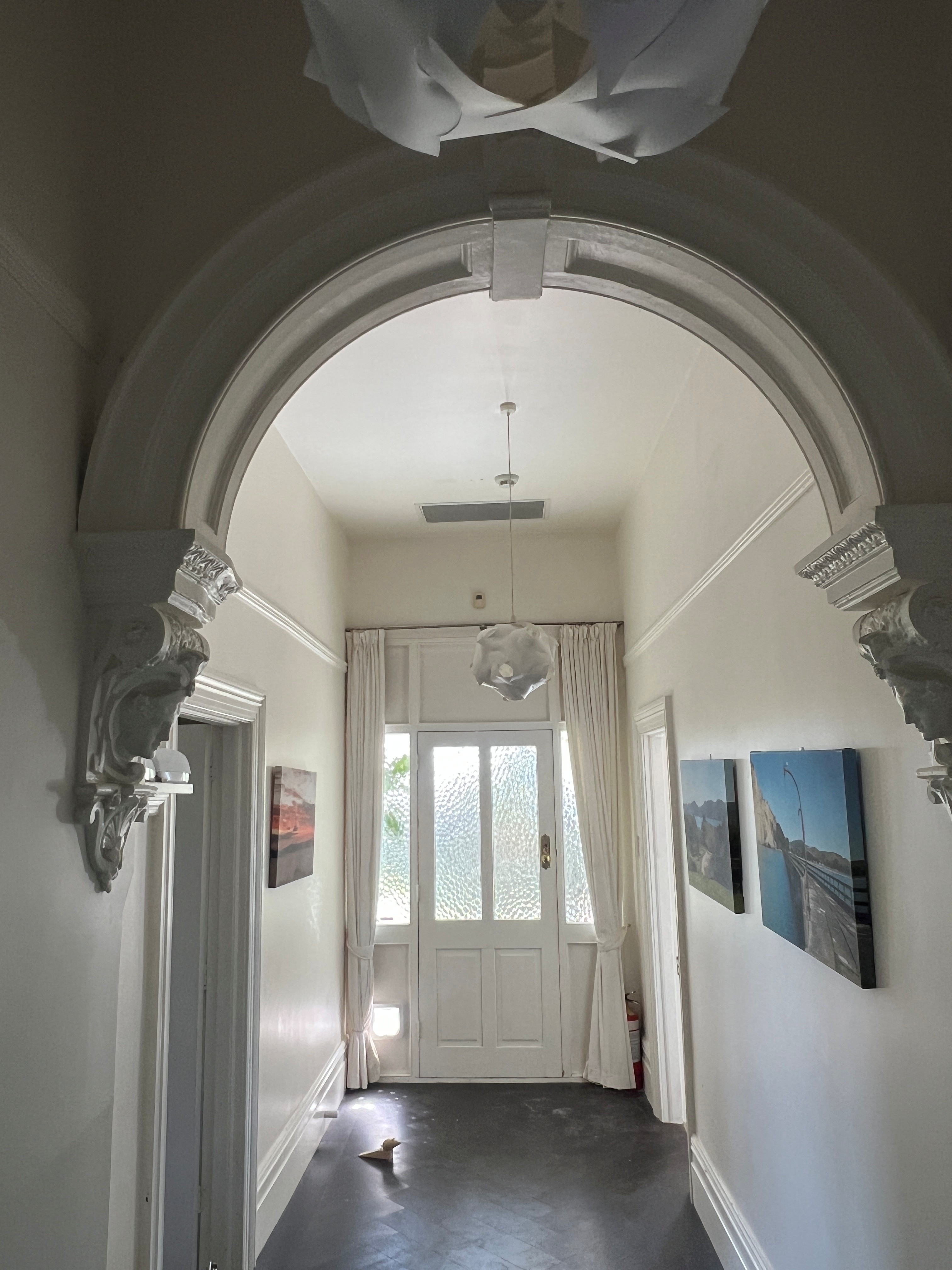 Return-air grille installed in the hallway beyond the villa's decorative archway.