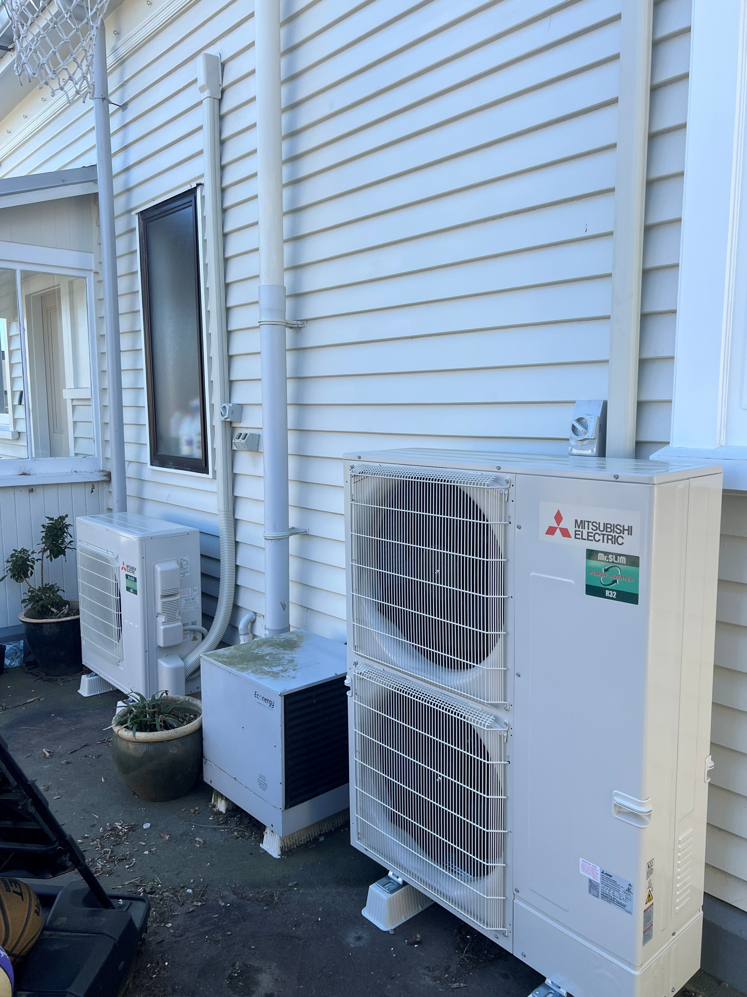 Two Mitsubishi Electric outdoor units serving the villa's separate living-area and bedroom ducted systems.
