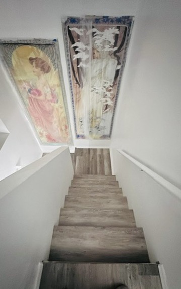 Overhead view of straight stair flight with luxury vinyl plank treads connecting cleanly to upper floor hallway