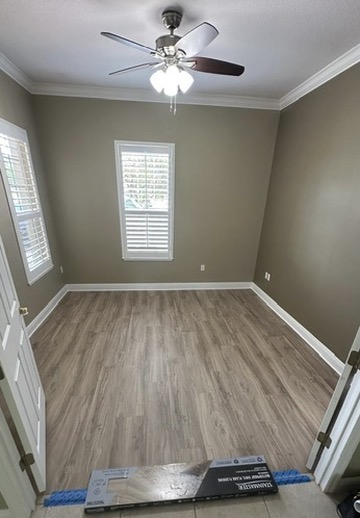 Wood-look plank flooring installed in a residential room with plantation shutters